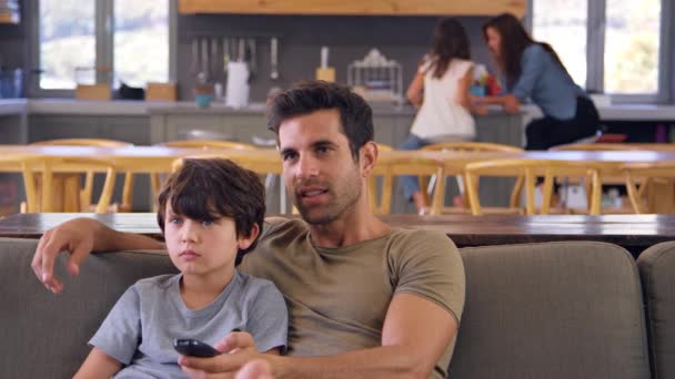 Vader en zoon die televisie kijken — Stockvideo