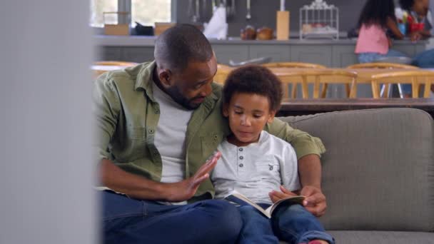 Otec a syn sedí na pohovce — Stock video