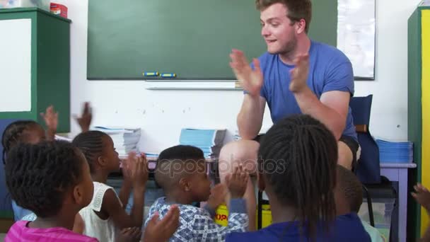 A gyerekek a padlón ül, és taps kezek — Stock videók