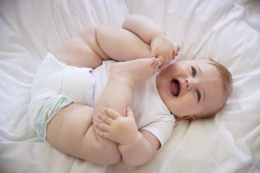 Baby Boy Lying On Parents Bed clipart