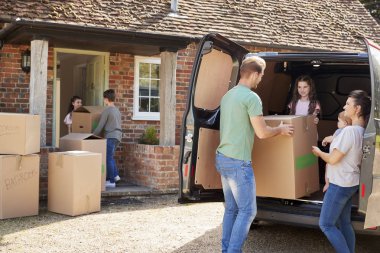 Family Unloading Boxes From Removal Truck  clipart
