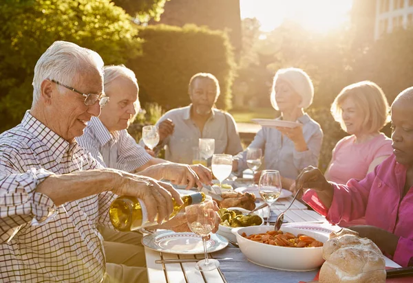 Senior przyjaciół ciesząc się kolacją na świeżym powietrzu — Zdjęcie stockowe