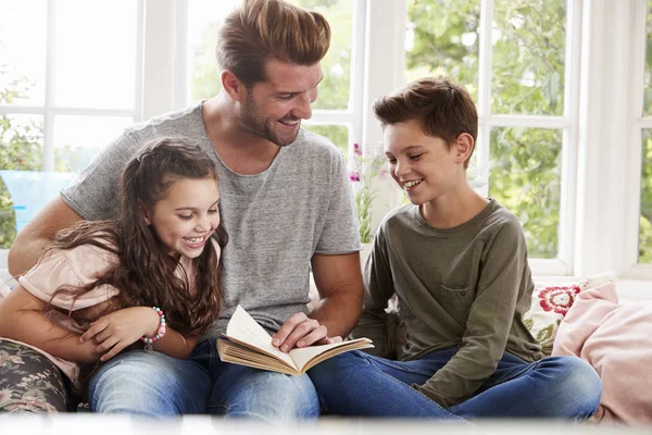 Vater liest Buch mit Sohn und Tochter — Stockfoto