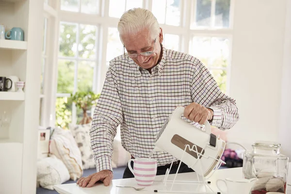 Senior mannen göra kopp te — Stockfoto