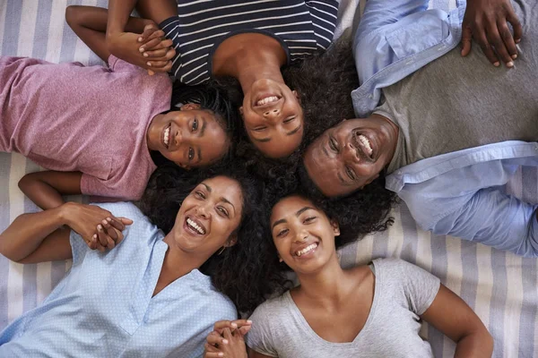Familj med tonårsbarn på säng — Stockfoto