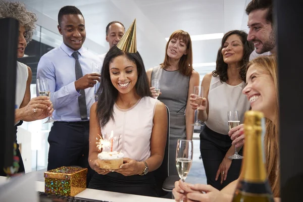 Kollegen versammelten sich am Schreibtisch der Frau, um zu feiern — Stockfoto