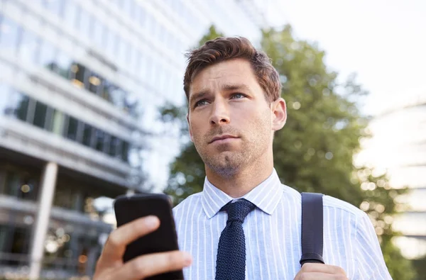 Biznesmen patrząc na telefon komórkowy — Zdjęcie stockowe