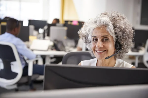 Mujer que trabaja en el ordenador con auriculares — Foto de Stock