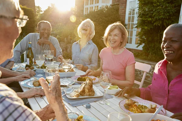 Amici anziani che si godono la cena all'aperto — Foto Stock