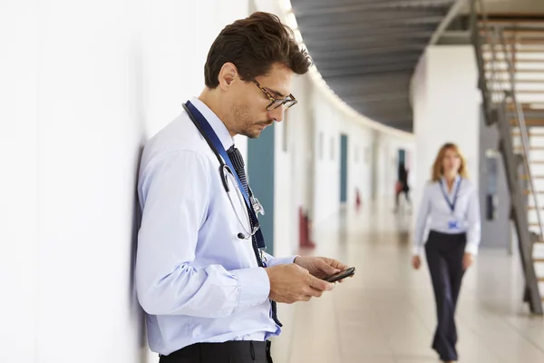 Médico varón con estetoscopio y smartphone — Foto de Stock