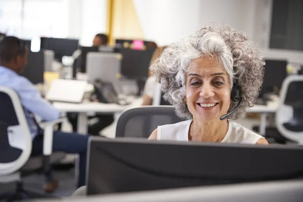 Donna che lavora al computer con auricolare — Foto Stock