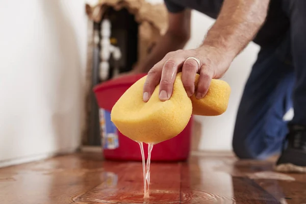 Hombre limpiando el agua del suelo — Foto de Stock