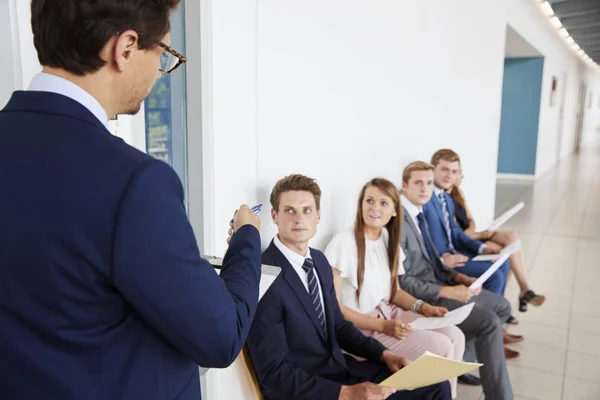 Recrutador abordando candidatos a emprego para entrevistas — Fotografia de Stock