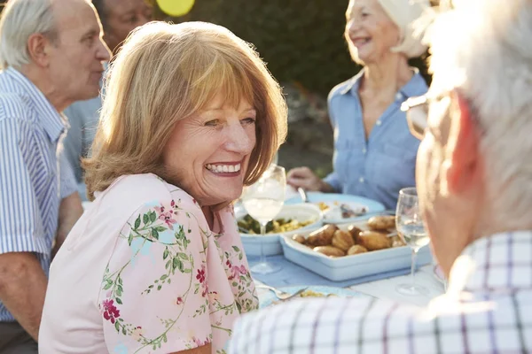 Senior vrienden genieten van diner in de buitenlucht — Stockfoto