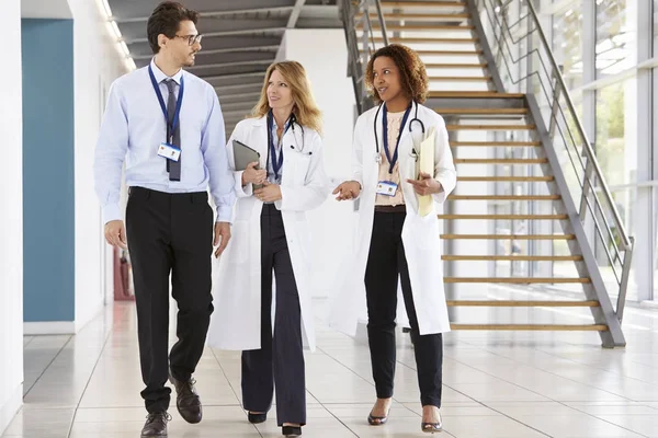 Drie mannelijke en vrouwelijke artsen wandelen — Stockfoto