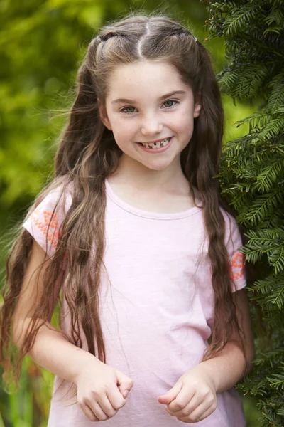 Souriant jeune fille debout en plein air dans le jardin — Photo