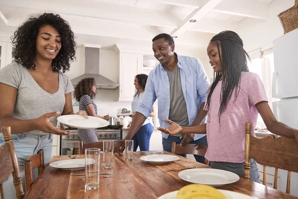 Familie leggen tabel voor de maaltijd — Stockfoto