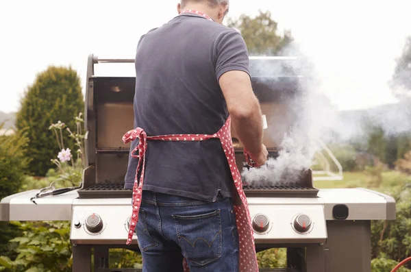 Homem queimando comida em um churrasco — Fotografia de Stock