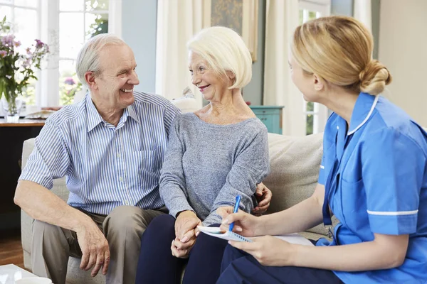 Kvinna sjuksköterska besök Senior par — Stockfoto