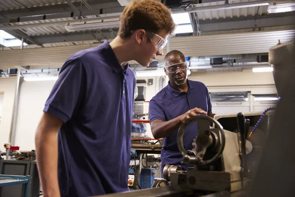 Engenheiro mostrando aprendiz como usar torno — Fotografia de Stock