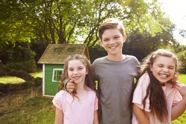 Children Standing In Garden Next To Playhouse — Stock Photo, Image