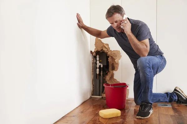 Uomo di mezza età con un tubo dell'acqua scoppiata — Foto Stock