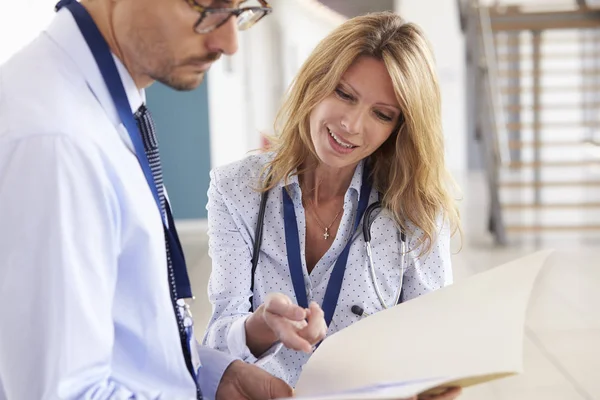 Doctores hombres y mujeres consultando notas —  Fotos de Stock