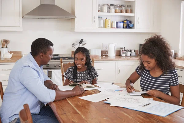 Vater hilft Töchtern bei Hausaufgaben — Stockfoto
