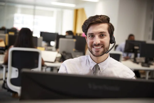 Hombre trabajando en la computadora con auriculares — Foto de Stock