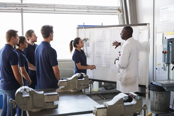 Ingenieur en vrouwelijke leerling presenteert op whiteboard — Stockfoto