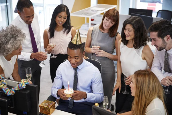 Colleagues gathered at mans desk to celebrate — Stock Photo, Image