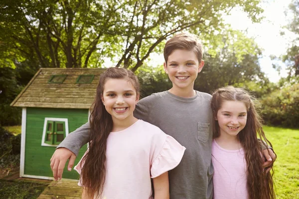 Enfants debout dans le jardin à côté de Playhouse — Photo