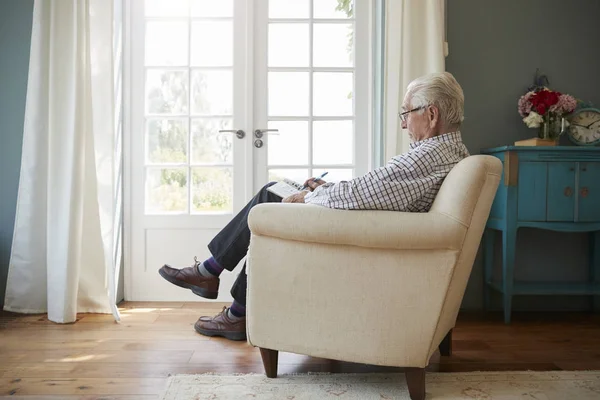 Äldre man som sitter i en fåtölj — Stockfoto