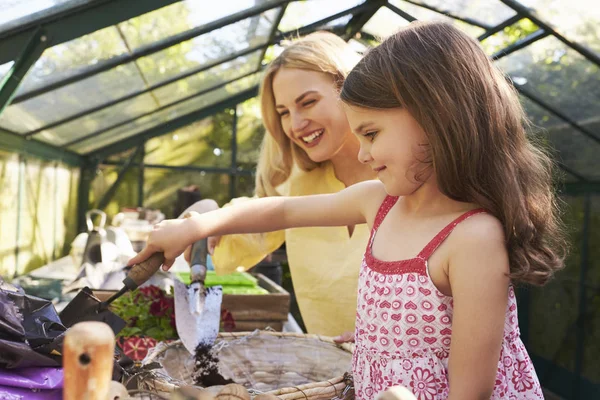 Mother And Daughter Planting Basket In Greenhouse — Stock Photo, Image
