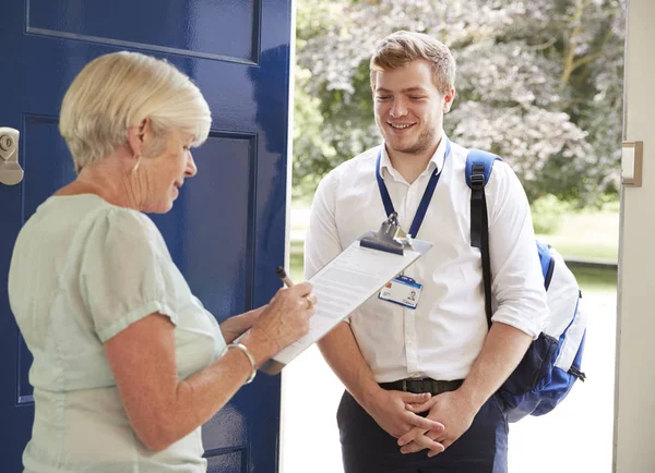 Senior Mulher Preenchendo Pesquisa Para Visitante Sua Porta Frente — Fotografia de Stock