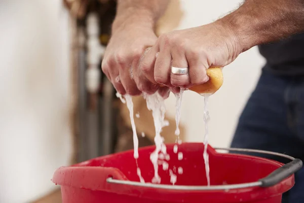 Man wringing water out of a sponge — Stock Photo, Image
