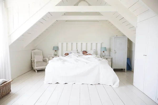 Pareja durmiendo en un dormitorio blanco — Foto de Stock