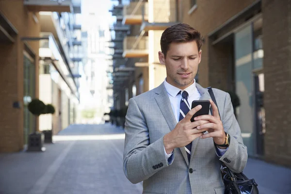 Zakenman kijken naar mobiele telefoon — Stockfoto