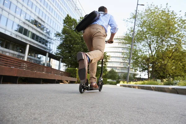 Geschäftsmann pendelt mit Roller zur Arbeit — Stockfoto