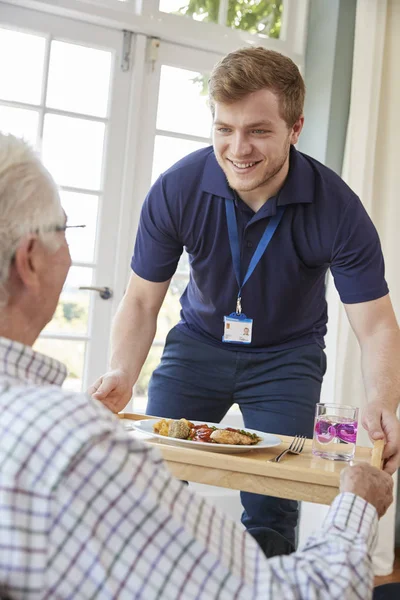 Zorg werknemer diner serveren senior man — Stockfoto