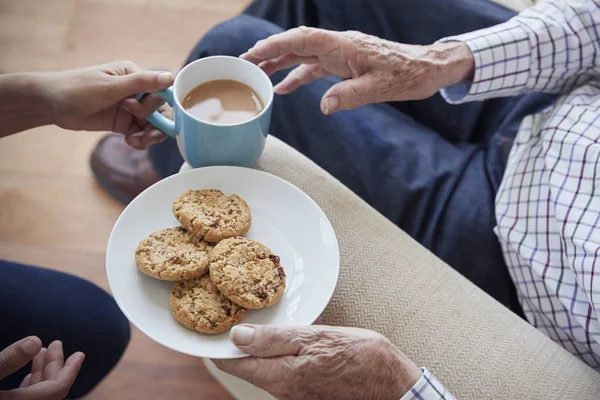 Vrouw passeert thee en koekjes — Stockfoto