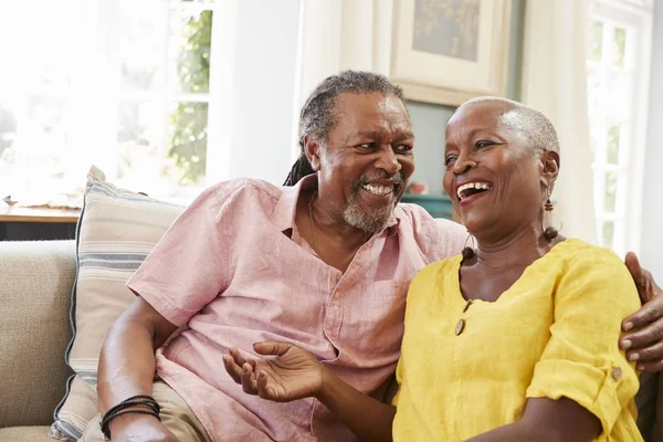 Couple âgé souriant sur le canapé — Photo