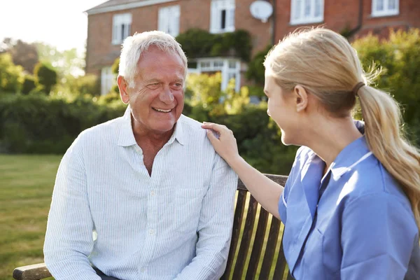 Verpleegkundige in gesprek met senior man — Stockfoto