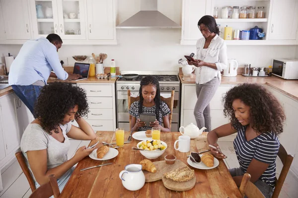 Rodina sedí kolem stolu se snídaní — Stock fotografie