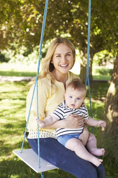Ritratto di madre giocare con bambino figlio su giardino swing — Foto Stock