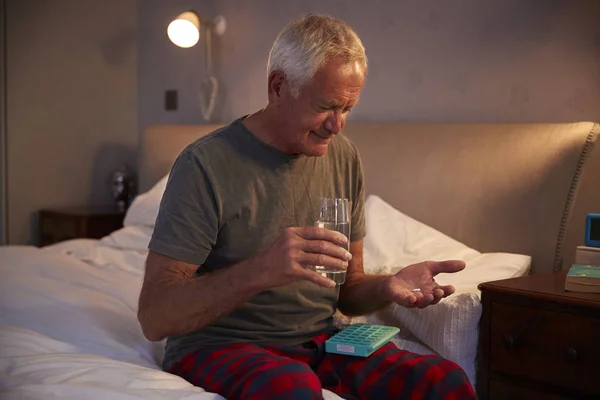 Senior sitzt auf Bett — Stockfoto