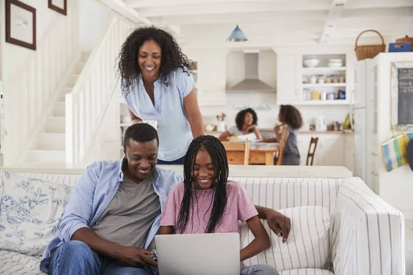 Família sentada no sofá com laptop — Fotografia de Stock