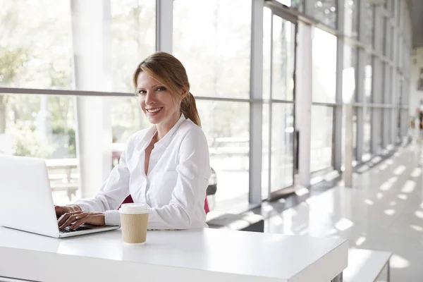 Businesswoman with laptop smiling — Stockfoto