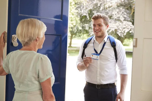 Senior Woman Opens Door Male Care Worker Showing His — Stock Photo, Image