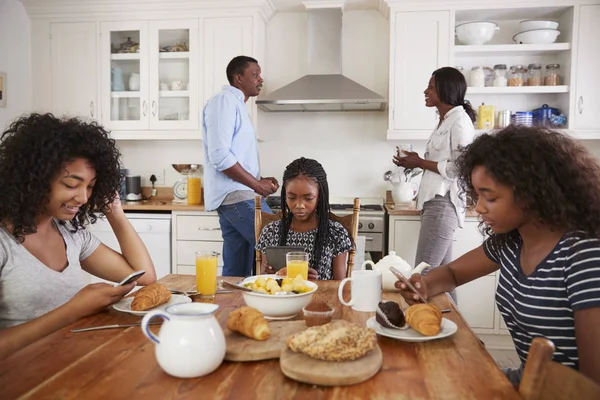 Familie zitten rond de ontbijttafel — Stockfoto